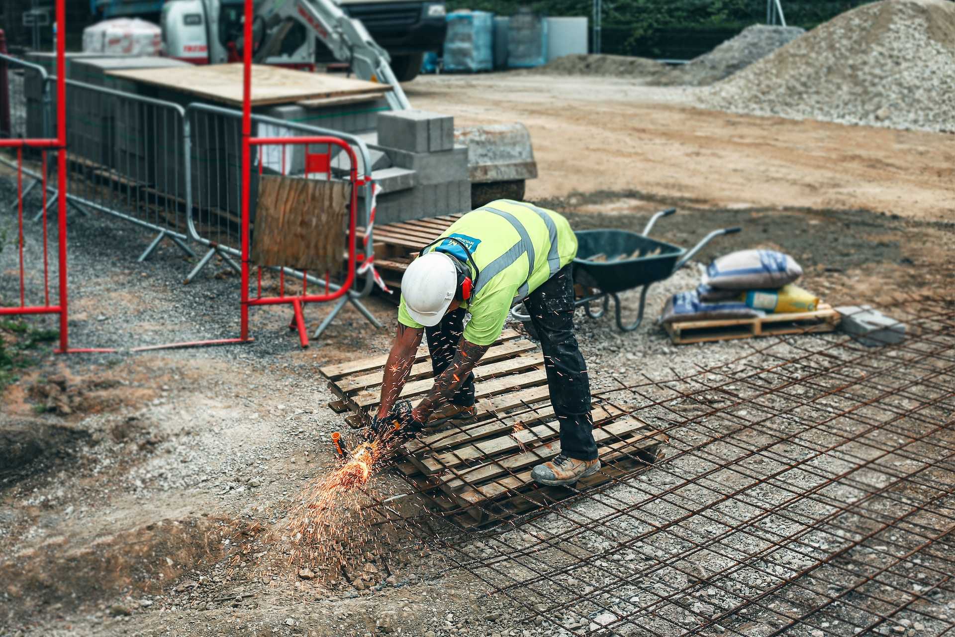 A construction worker in a high-vis jacket does some building work.